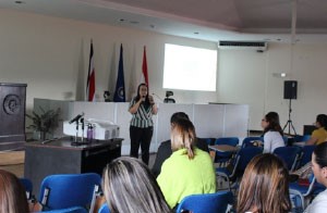 Mujer brindando una conferencia sobre los factores psicosociales laborales
