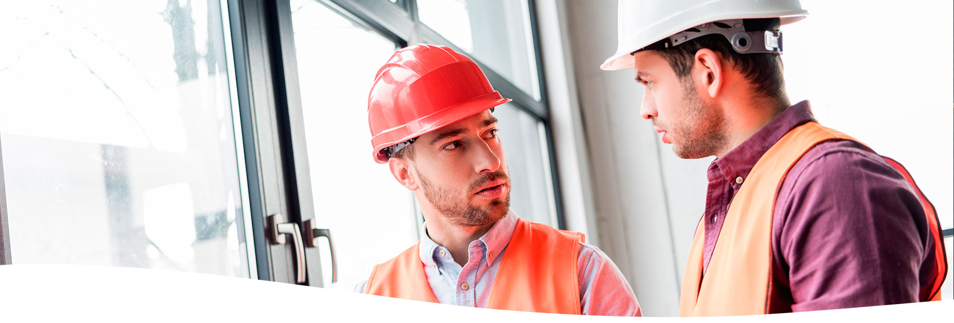 Ingenieros dialogando, utilizando equipo de seguridad y sujetando un extintor